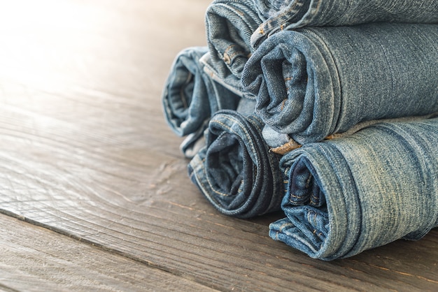 stacks of jeans clothing on wood 