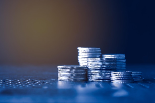 Стеки денег монеты с синим фоном фильтра Концепция финансовых инвестиций