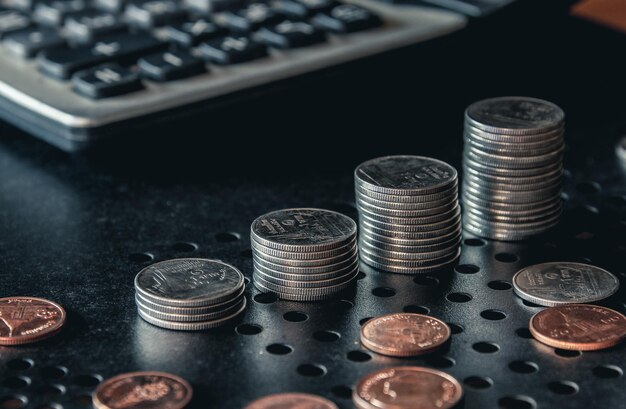 Фото Стопки денежных монет с калькулятором концепция бизнеса и финансовых инвестиций