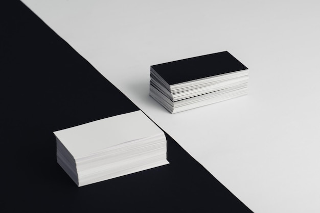 Фото Стопки белых и черных пустых визитных карточек на черно-белом фоне
