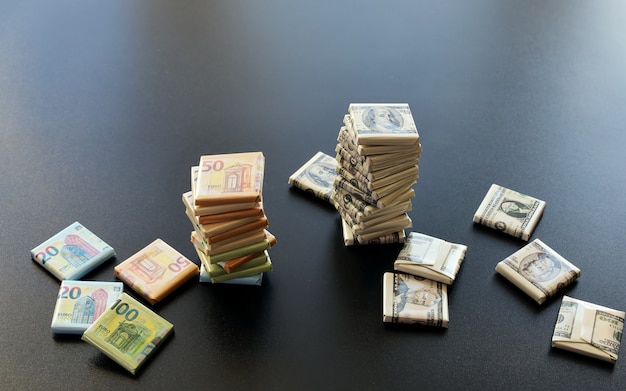 Стеки упакованных предметов в денежные символы знаков евро и долларов