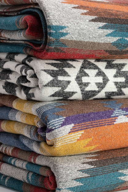 Stacks of Pendletonstyle woolen bedspreads in different colors are neatly folded Gift accessory studio shot