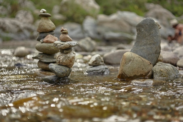 Stacks of rocks and pebbles in the middle of the flowing of a stream 