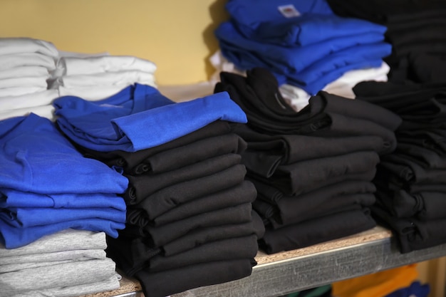 Stacks of t-shirts prepared for printing on shelf