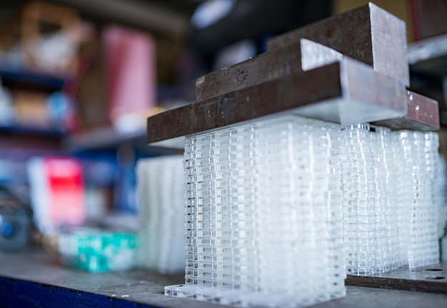 Stacks of transparent glass containers under press for TFT displays in assembling workshop of production plant extreme close view