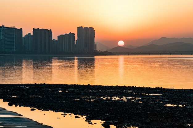 Stad en rivier bij de zonsondergang