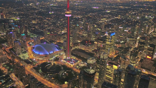 Foto stad toronto 's nachts, vol lichten, kijk naar de cn-toren, met hoge gebouwen eromheen,