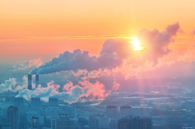 stad vanaf het observatiedek tot wolkenkrabbers in de ondergaande zon en schoorstenen met rook Moscow City