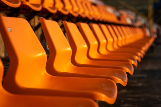 Foto stadionstoelen op oranje kleur.