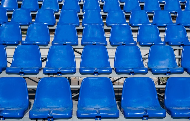 Stadium seats background rows of blue plastic empty chairs