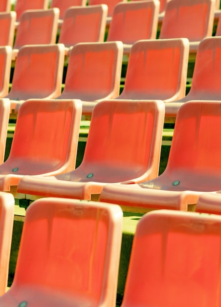 Stadium seats, red color. Soccer, football or baseball stadium tribune without fans