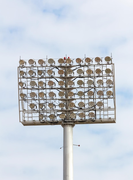 青い空を照らすスタジアムのスポットライトタワー