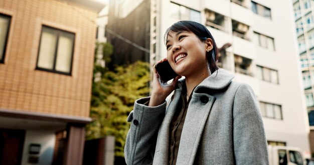 Stads telefoongesprek en vrouw met zakelijke glimlach en lopen met netwerk gesprek en communicatie Japan persoon of werknemer met een smartphone verbinding of praten met contact of digitale app