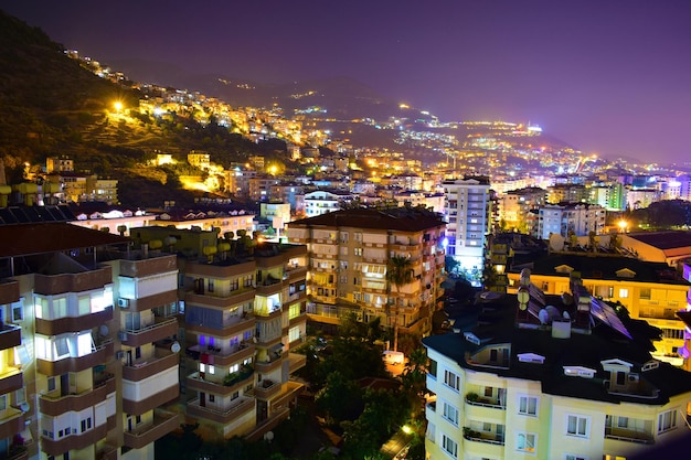 Stadsbeeld van moderne huisjes met meerdere verdiepingen op een berghelling in de nacht Turkije Alanya
