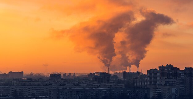 Stadsdistrict op zonsondergang in de winter. Industriële fabriek op achtergrond