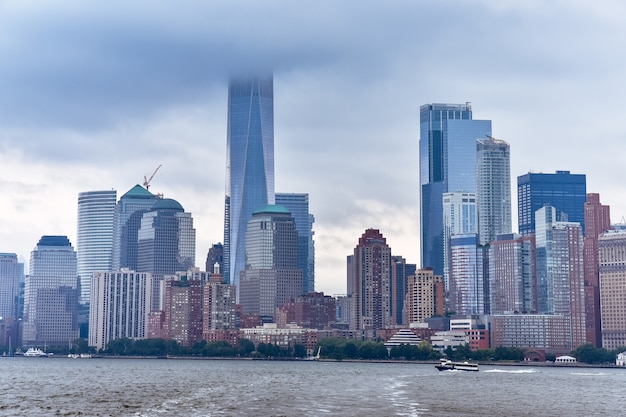 Stadsgezicht van het financiële district van Manhattan van Liberty Island, in een mistige dag.