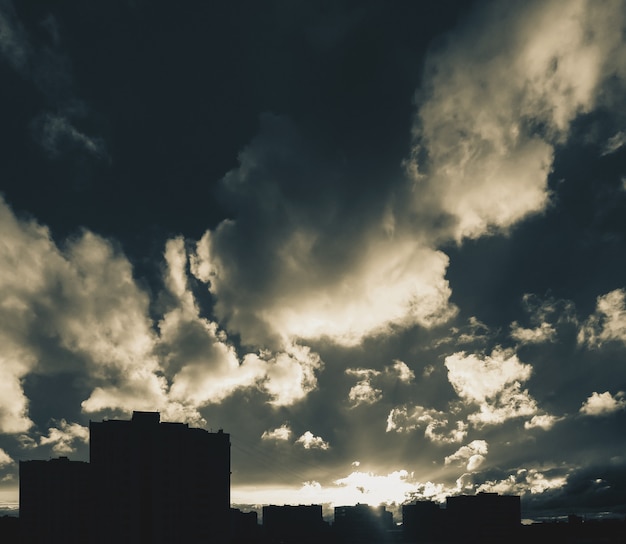 Stadshorizon met dramatische bewolkte hemel bij zonsondergang