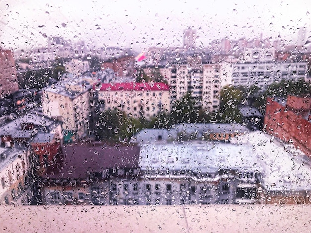Stadslandschap gezien door een nat raam tijdens het regenseizoen