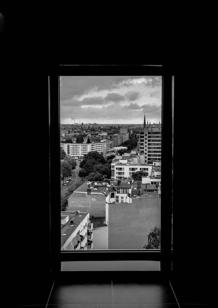 Stadslandschap tegen de lucht gezien door een raam