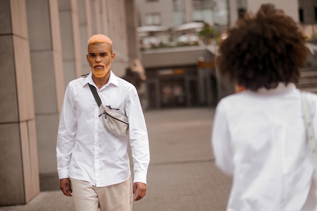 Stadsleven. Twee jonge mensen in het wit die op straat lopen