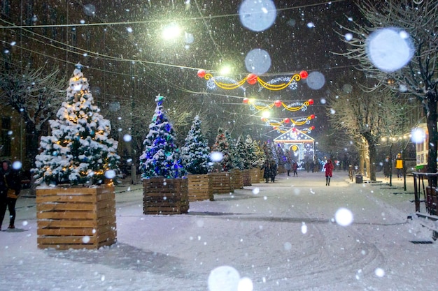 Stadsstraat tijdens sneeuwval in de winternacht mooie verlichting