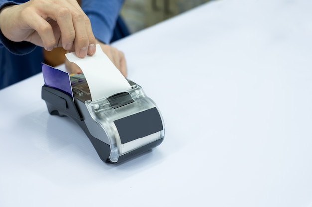 Staff cashier rip bill paper with card on payment terminal