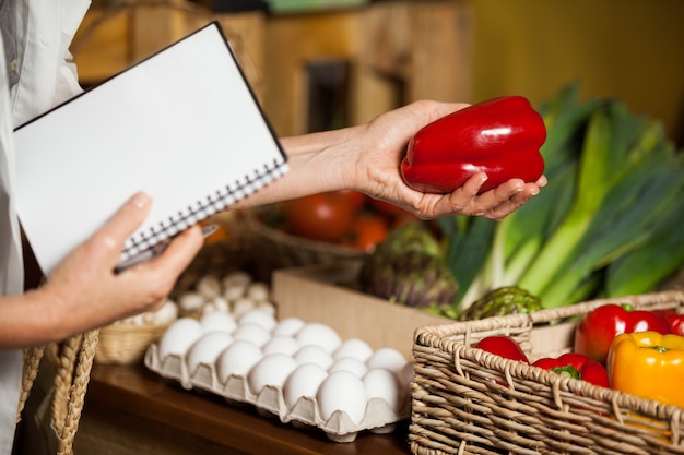 Staff checking red bell pepper in organic section