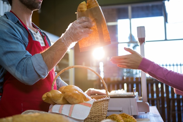 Staff giving packet bread to customer