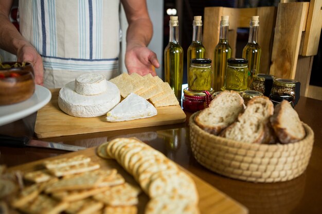 Staff standing near various cheeses at counter