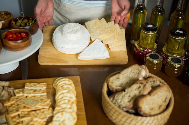 Staff standing near various cheeses at counter