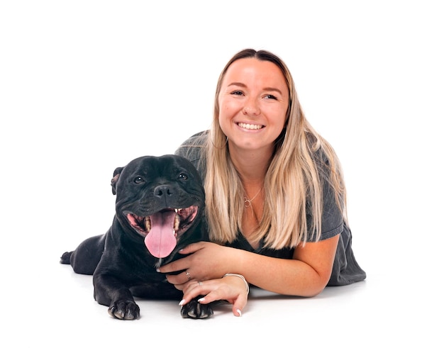 staffordshire bull terrier and woman in front of white background