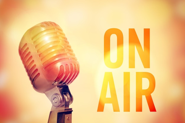 Stage microphone on a glowing abstract background with an inscription On Air Toned