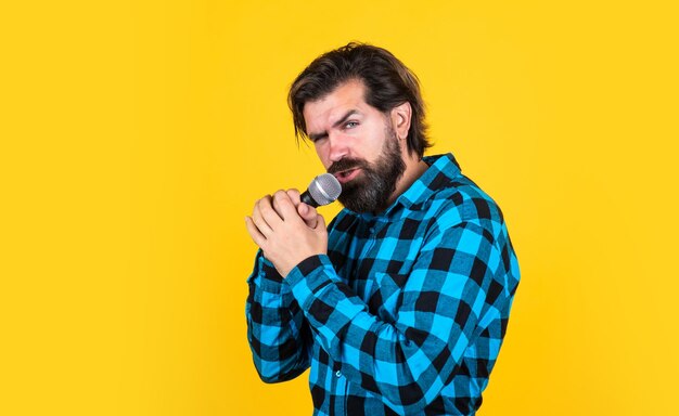 Stage performer singing man wearing checkered shirt confident
male singer in karaoke club performance on party bearded hipster
sing a song in microphone guy with mic concept of music