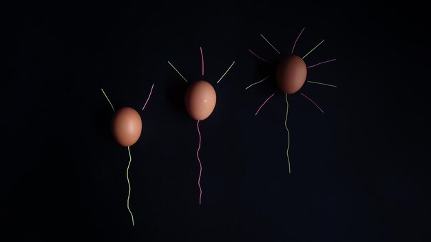 Photo stages of egg balloons to glow on a dark background