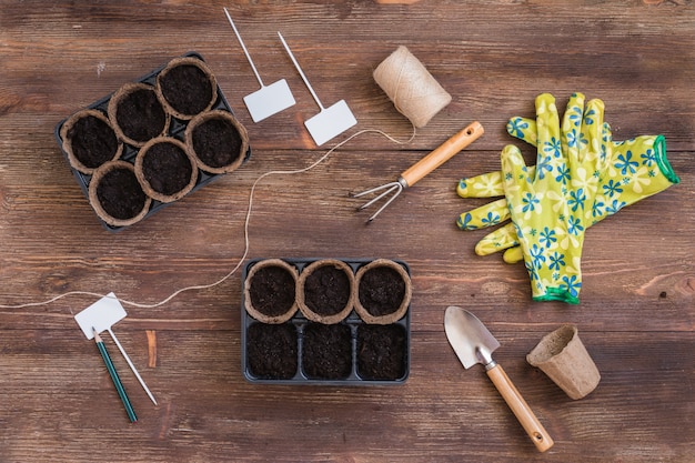 Этапы посадки семян, органические горшки с почвой, садовые инструменты и посуда
