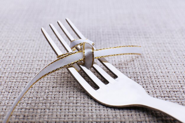 Photo stages of tying bow on fork closeup