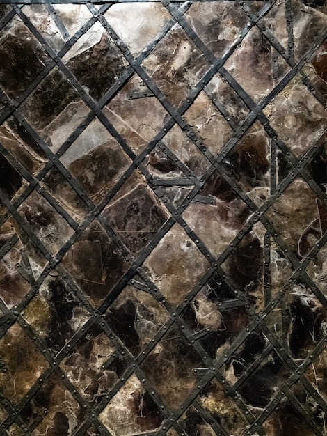витражное окно с готическим рисунком из кованого железа и заклепок, потрескавшееся стекло