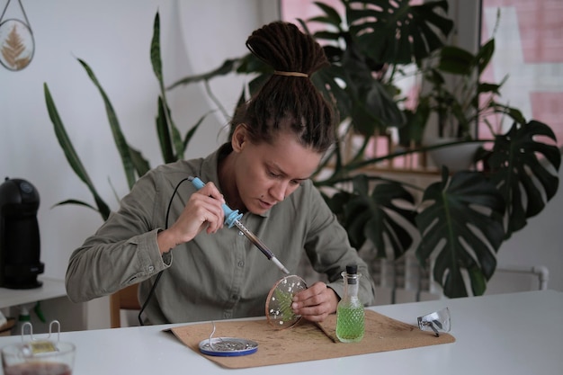 Stained glass maker works with colorful souvenirs Female hands soldering the stained glass learning how to make stained glass finishing handicrafts soldering gun