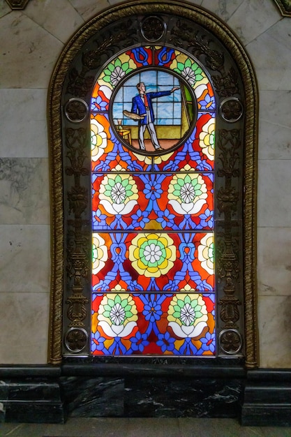 A stained glass window with a man on the top of it