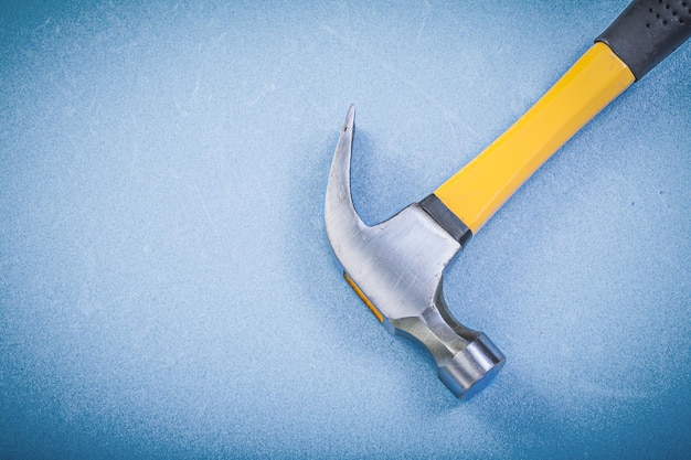 Stainless claw hammer on blue background construction concept