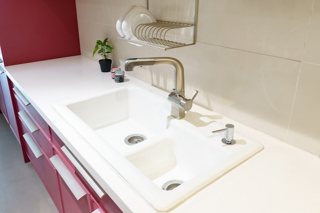 Foto lavello da cucina in acciaio inox e acqua di rubinetto in cucina. appliance integrate. elettrodomestico da cucina