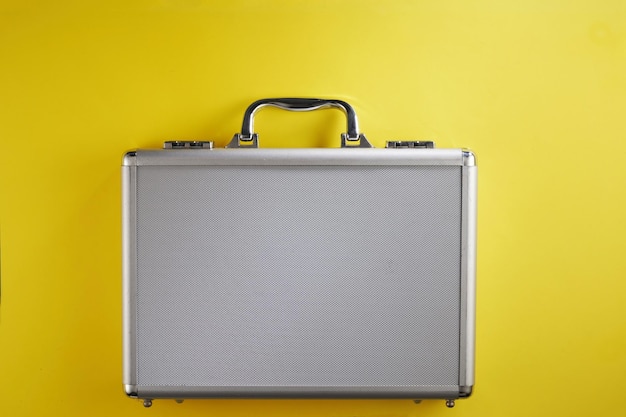 Photo stainless steel brief case against yellow background