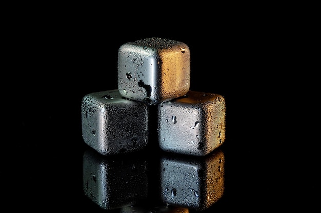 Stainless steel cubes simulating ice for cooling drinks on a black surface with a reflection