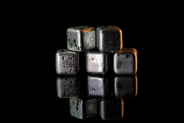 반사가 있는 검은 표면에 음료를 냉각하기 위해 얼음을 시뮬레이션하는 스테인리스 스틸 큐브