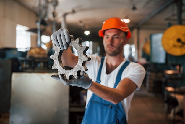 Stainless steel. Man in uniform works on the production. Industrial modern technology.