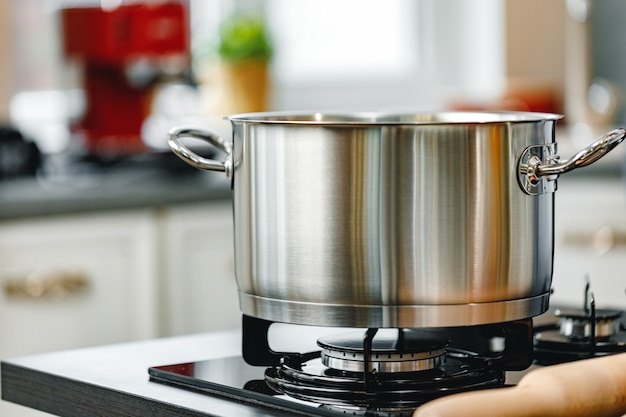 Stainless steel pot on a gas stove in kitchen close up photo