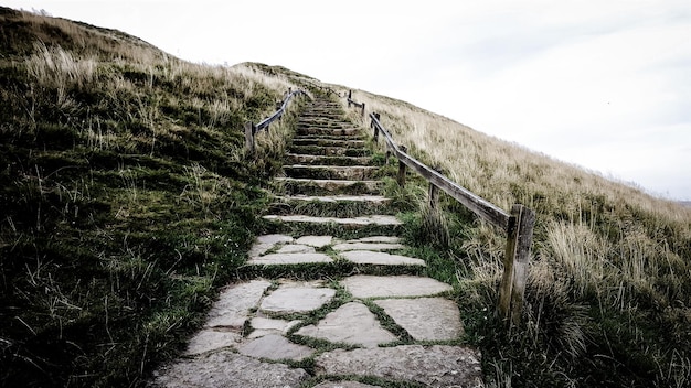 Photo staircase on grassy hill against sky