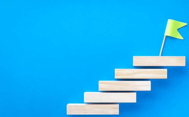 Staircase made of blocks and a green flag on a blue background