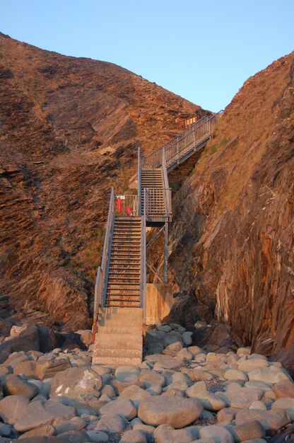 Staircase over rocks against sky