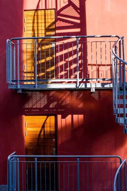 Staircase and shadow Gray metal stairs next to the wall of the orange building